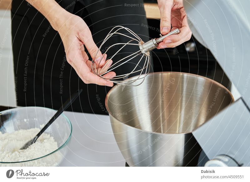 Woman put in whisk nozzle in electric mixer kitchen bowl appliances woman mixing food background bakery blender caucasian cook cooking cuisine dough electronic