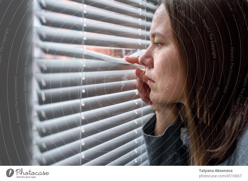 Anxious woman looking to window anxious loneliness depression unhappy despair worried suffering frustrated depressed lonely one person home emotion indoor