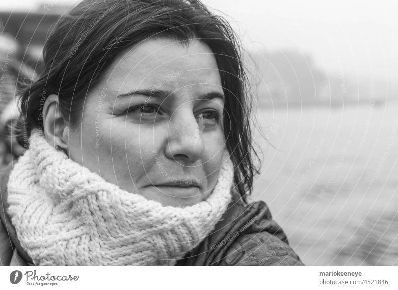 Portrait of middle aged woman wearing a scarf in grayscale outside horizontal mature one person ocean lady expression femininity calm portrait female hair