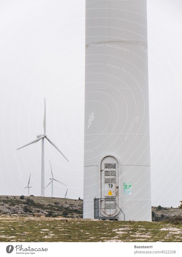 Wind farm in the mountains. Tower of a wind turbine with door to the ascent. In the background more turbines. Wind energy plant 19 Energy Renewable energy