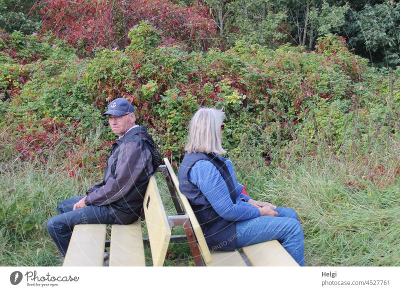 thick air - man and woman sitting back to back on two benches in nature Human being Man Woman Senior citizen out Nature Difference of opinion quarrel Ignorance