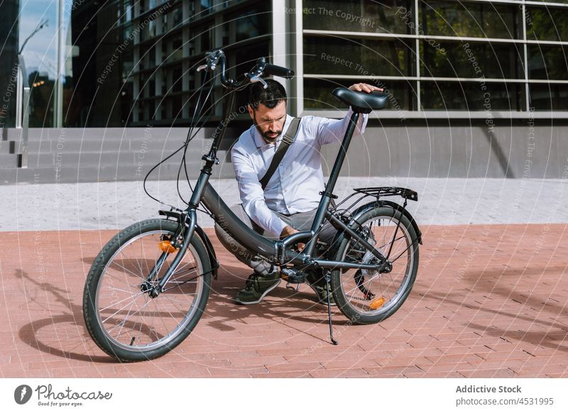 Male worker checking wheel of bicycle man fix executive chain park formal repair male transport serious inspect examine detail busy attentive problem cyclist