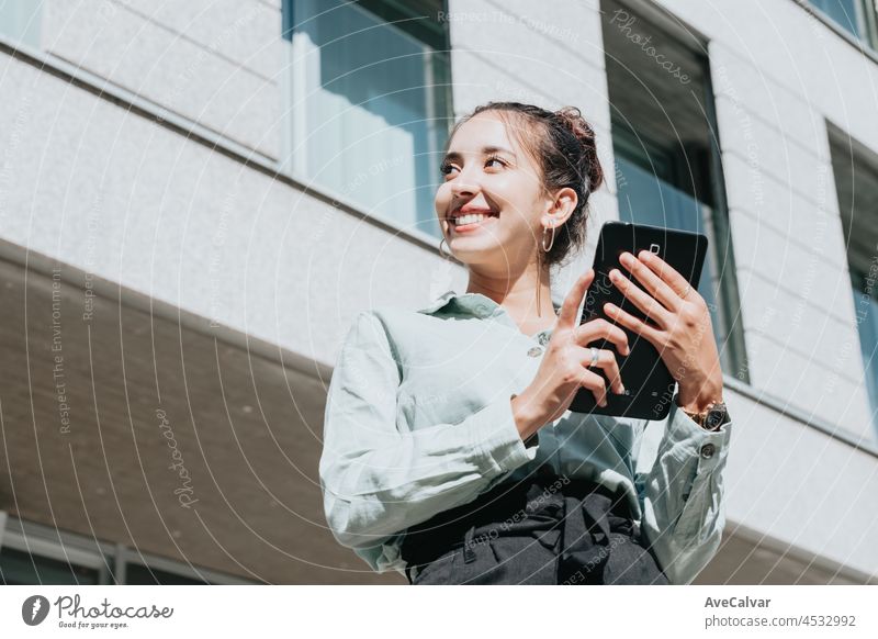 Young arab woman entrepreneur woman smiling,using a tablet for digital purposes, outdoors. Looking to the left with Copy space, Business concept, portrait of office