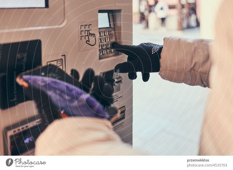 Woman buying parking ticket at park machine using smartphone and contactless method of payment wireless mobile phone paying woman smart phone communication