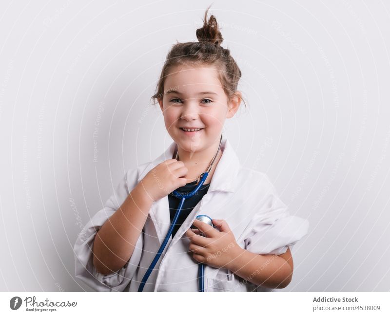 Cheerful girl in doctor outfit stethoscope disguise play medical playful childhood instrument cheerful happy positive studio eyeglasses medicine adorable