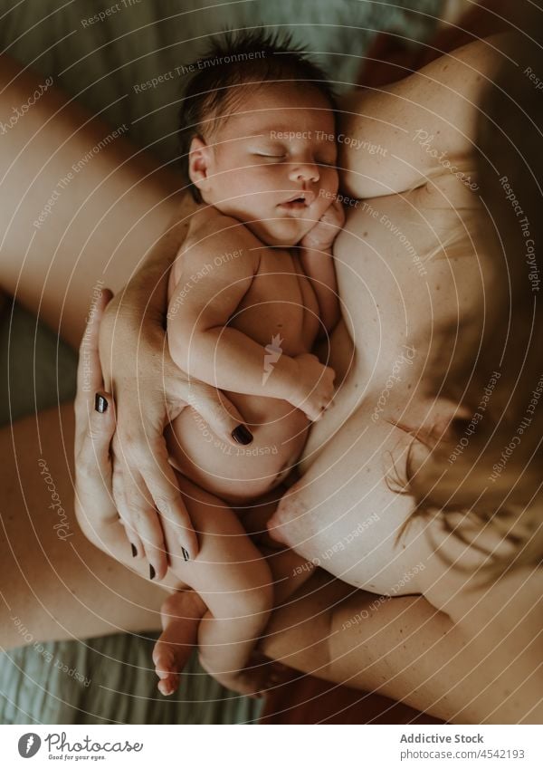 Anonymous mother hugging newborn on bed dreamily woman baby embrace breastfeed love motherhood childcare topless female young home peaceful bedroom comfort
