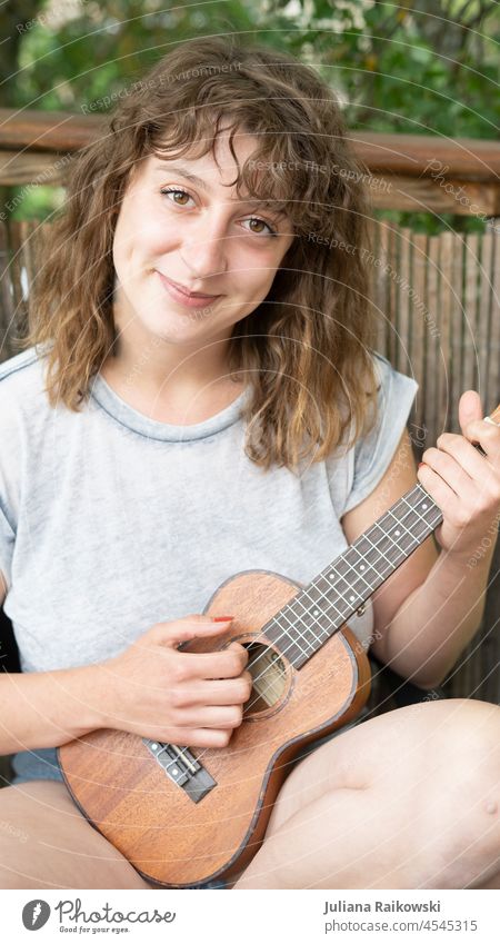 Woman playing ukulele in garden Practice Cozy Live Make music Song Feminine Girl pretty Artistic artist Musician Cool (slang) Acrobat Sit Youth (Young adults)
