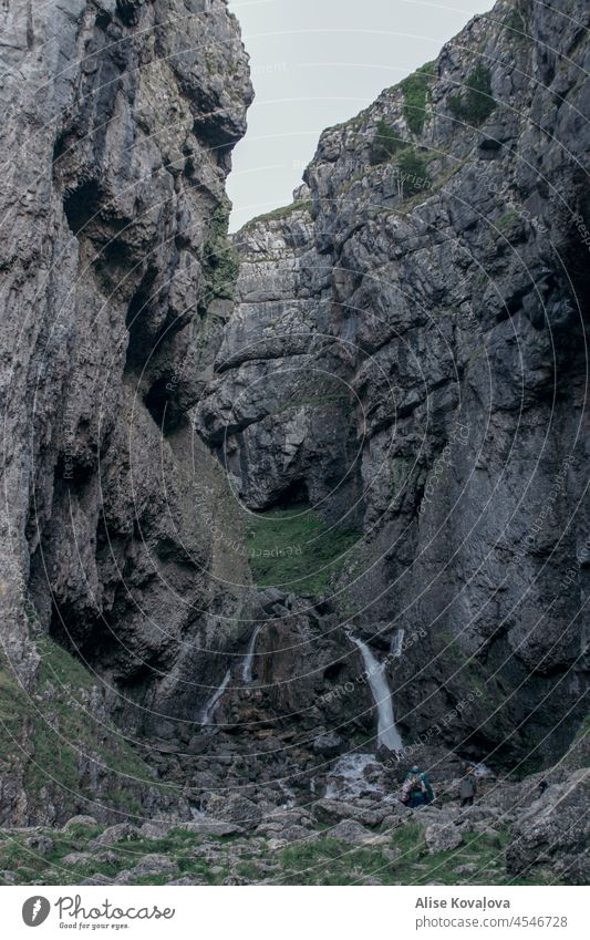 cliff and a waterfall in england stone sandstone cliffs nature scenery rock rocky grass landscape tourism mountain hill view travel natural grey green