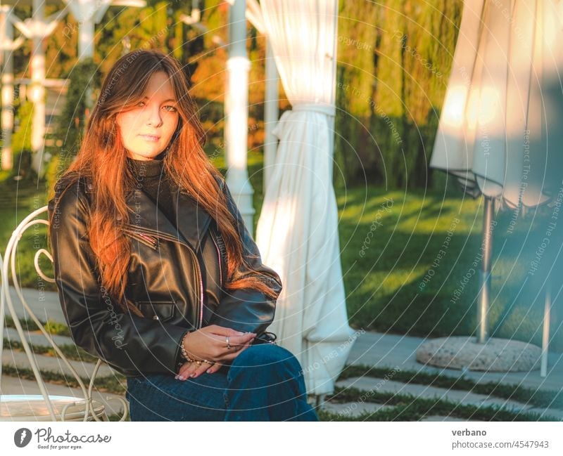 girl wearing blue jeans and leather jacket sit outdoors at sunset - a  Royalty Free Stock Photo from Photocase