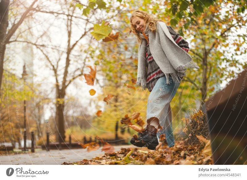 Happy young woman in autumn park one person adult beautiful casual female girl people lifestyle urban city street attractive town portrait millennials Warsaw