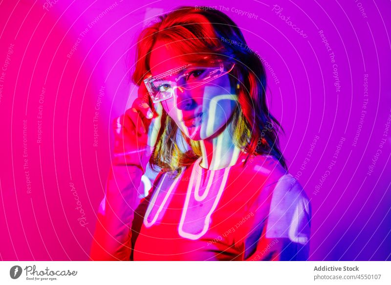 Young Woman In Projector Lights with led futuristic glasses projector bright color colorful confident videogame technology contemporary cool creative dark