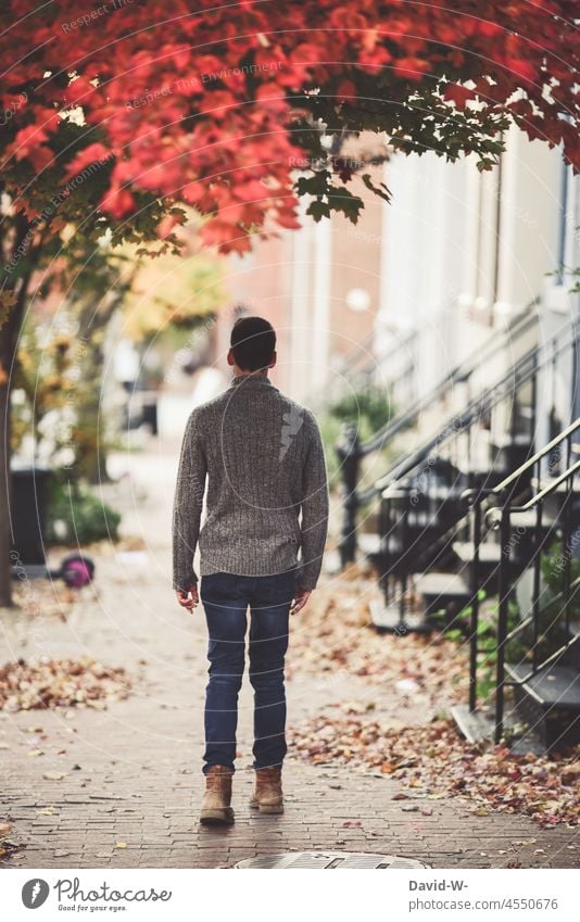 Man walks in a city in the fall stroll Autumn autumn walk Town downtown Autumnal colours Early fall Autumnal weather off Rear view