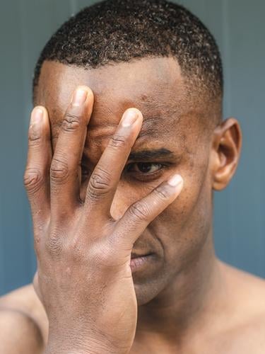 portrait of an young topless fit african male model afro american man expression shirtless hands muscular muscled emotion posing grey background body handsome