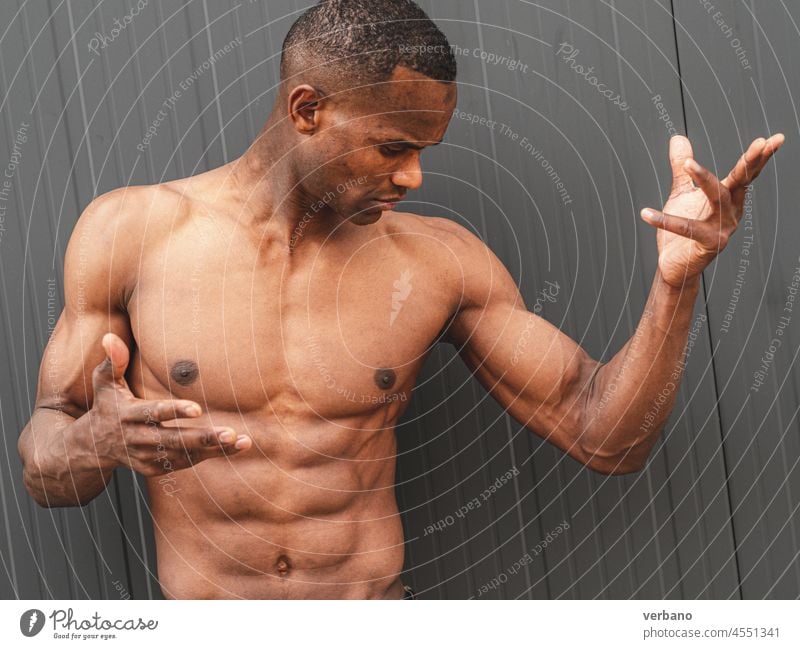 portrait of an young topless athetic african man afro american male expression shirtless hands muscular muscled emotion posing model grey background body