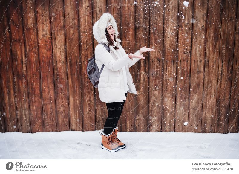 cheerful caucasian young woman playing outdoors with snow and snowflakes, fun and winter lifestyle park mountain snow flake snowing leisure happy smiling 30s