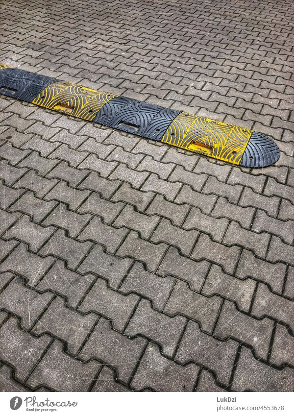 Black and yellow Speed bump on a road on the street on the roadway Transport Driving tempo Road traffic Street Traffic lane Safety Slow down slower Slowly