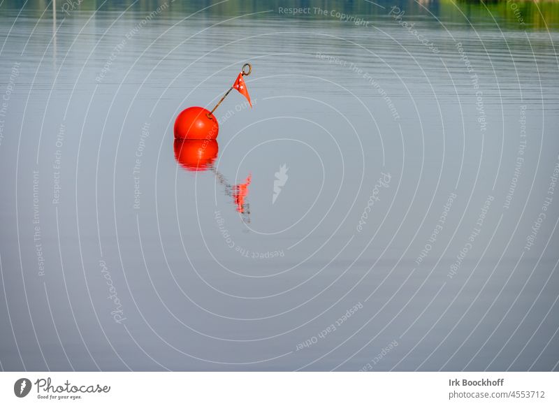 Red anchor buoy in glassy water - a Royalty Free Stock Photo from
