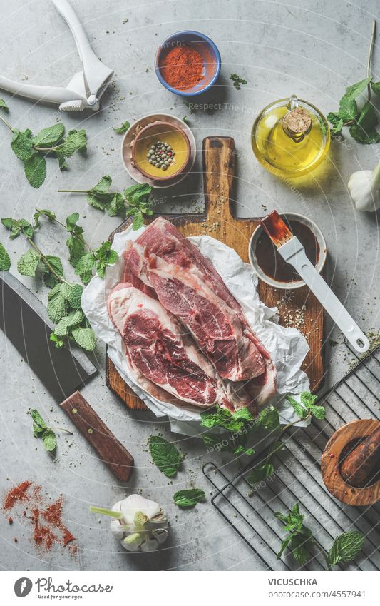 https://www.photocase.com/photos/4557941-raw-meat-pieces-on-wooden-cutting-board-with-oil-spices-marinade-herbs-and-cooking-utensils-on-grey-kitchen-table-cooking-and-grill-preparation-at-home-with-flavorful-homemade-marinade-top-view-dot-photocase-stock-photo-large.jpeg