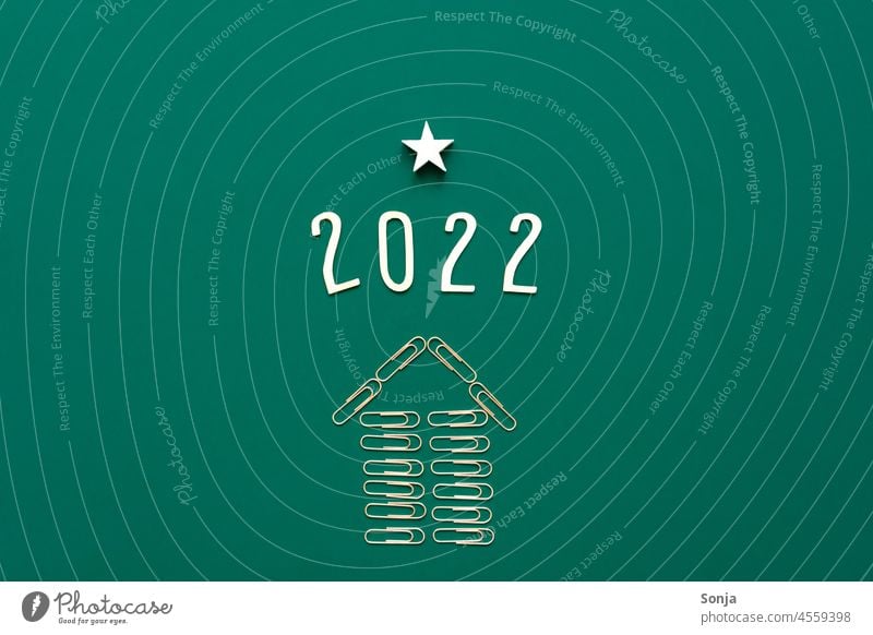 2022 and an ascending arrow made of paper clips on a green background. Top view. Arrow Paper clip Success Career Future Target Direction Trend-setting Forwards