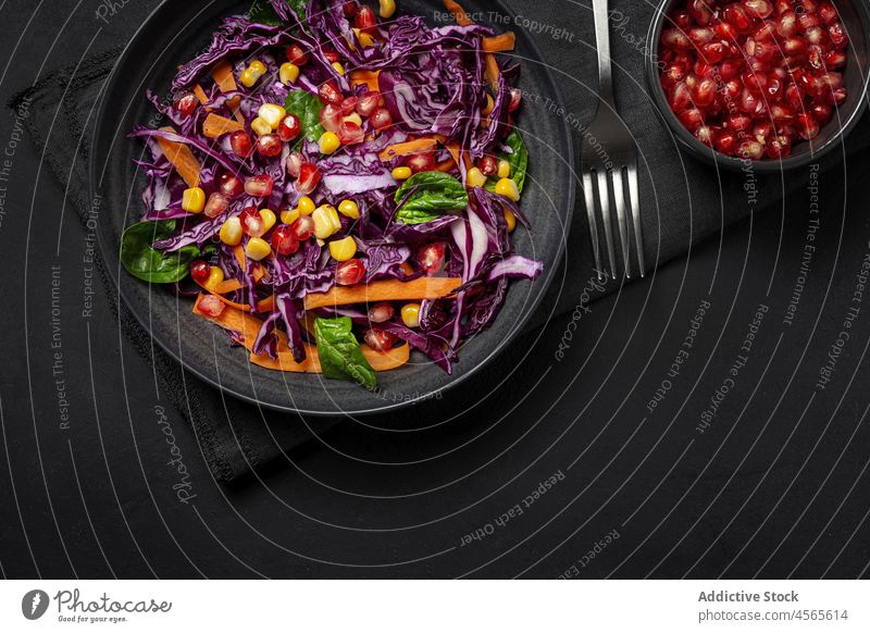 Homemade Purple Cabbage Salad with Corn, Carrots, Pomegranate and Spinach food purple cabbage corn spinach grenade carrot white background fresh vegan food diet