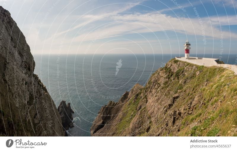 Lighthouse on rocky cliff near calm sea in sunny day lighthouse seascape seashore picturesque scenic spectacular coast ocean spain galicia seaside coastline