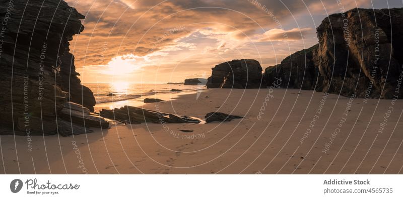 Rocky coast with sandy beach and serene sea sunset sundown shore twilight cliff nature picturesque beach of the cathedrals formation paradise galicia scenery