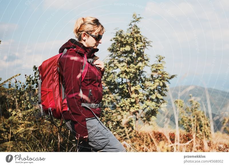 Woman with backpack hiking in mountains, spending summer vacation close to nature adventure trip travel trekking woman active journey wanderlust tourist
