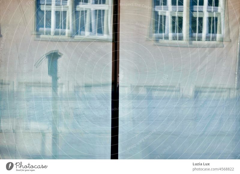 The window panes of an empty street café and the foils hanging behind them reflect the façade opposite. Glass Pane Window pane vacant depends Concealed Slice