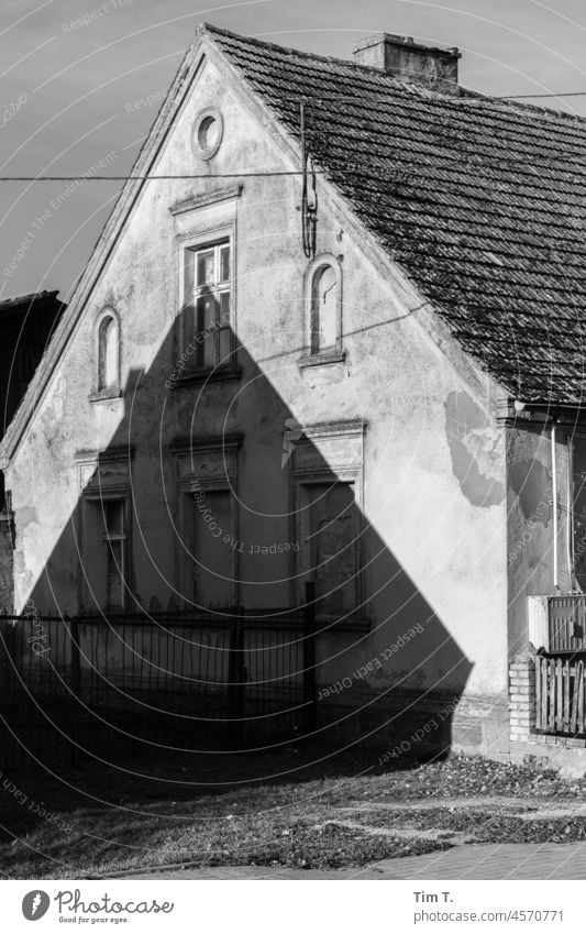the gable of an old house casts a shadow on another old house Shadow House (Residential Structure) Village Gable end b/w bnw Poland Winter Day