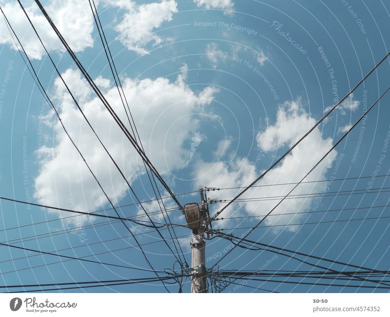 Street lamp and power post in a against high sky with clouds in summer electric line Power post Energy Connection Sky Clouds Nature vs Technology stream Summer