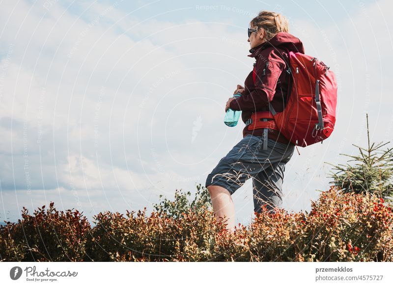 Woman with backpack hiking in mountains, spending summer vacation close to nature adventure trip travel trekking woman active journey wanderlust tourist