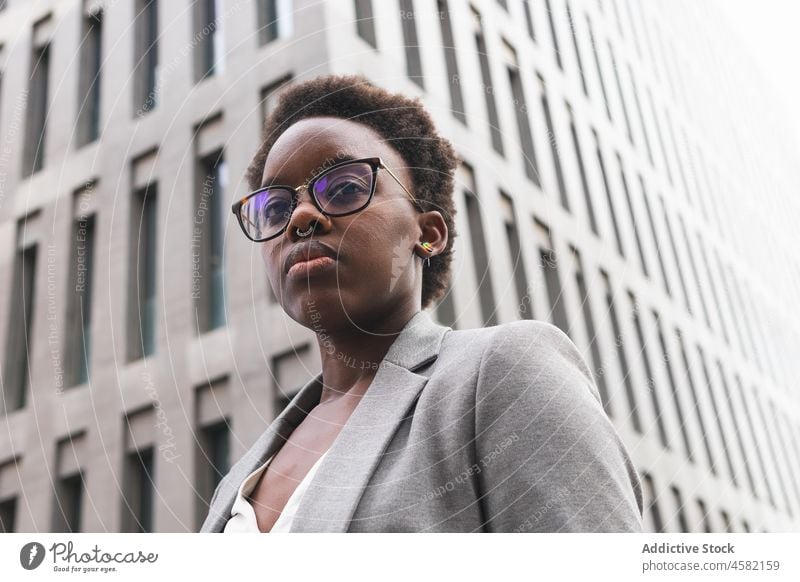 Stylish confident black businesswoman near modern office building entrepreneur city skyscraper street classy downtown eyeglasses jacket manager well dressed