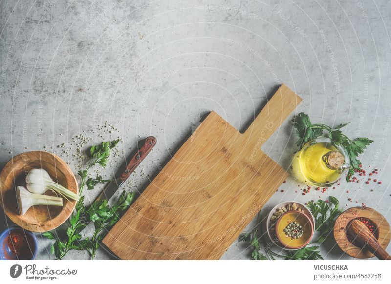 https://www.photocase.com/photos/4582258-food-background-with-wooden-cutting-board-fresh-herbs-garlic-olive-oil-mortar-and-pestle-kitchen-knife-and-spices-on-grey-kitchen-table-cooking-preparation-with-flavorful-ingredients-top-view-dot-photocase-stock-photo-large.jpeg