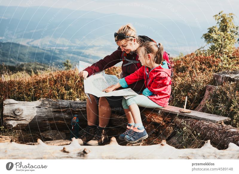 Family trip in mountains. Mother and her little daughter examining