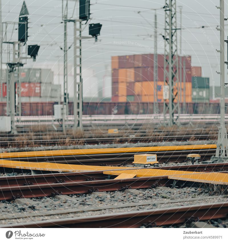 Railroad tracks and overhead line poles in front of containers Track rails railway tracks Overhead line mast Container Rail traffic freight traffic Envelope