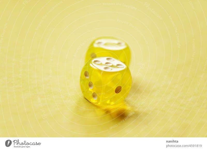 A vibrant monochromatic macro with depth of field about two yellow glass gambling dice with two numbers, two and five on a yellow background. luck game bet