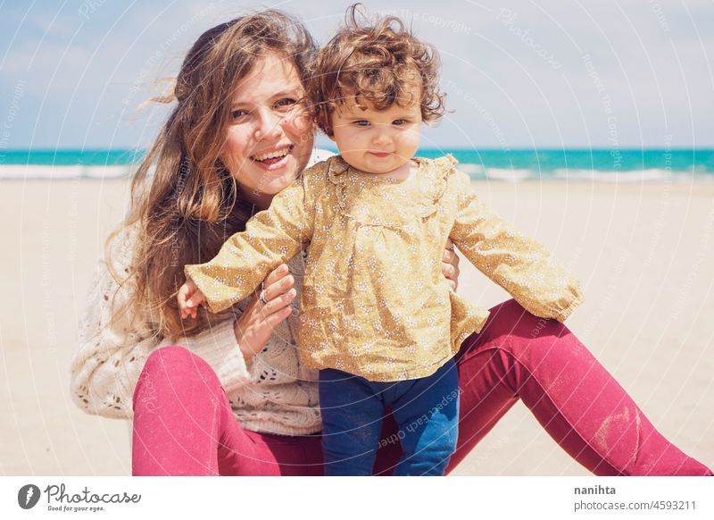 Young mom playing at the beach with her child baby family holidays single parent parenting motherhood young youth blonde playful fun funny happy happiness