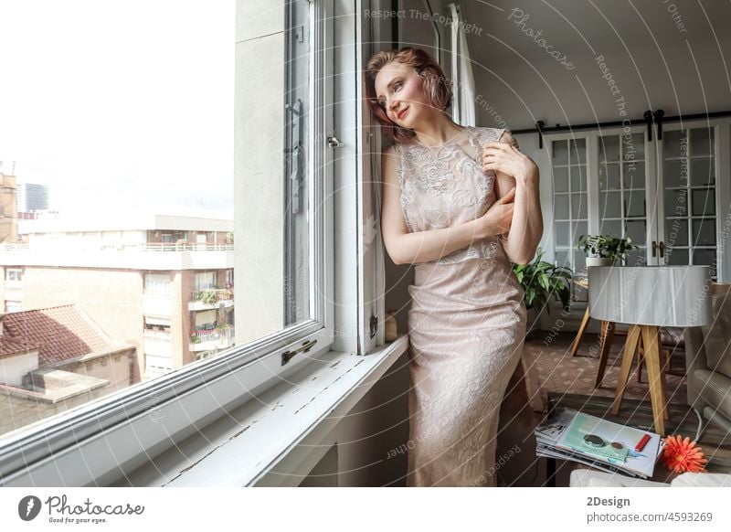 Young woman in dress looking out the window standing person caucasian lady girl leaning looking away stylish model melancholic depressing pensive sad melancholy