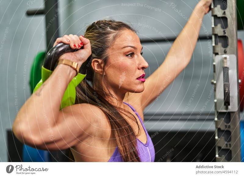 Athletic sport woman with perfect fitness body doing squat in gym with  kettlebell - Stock Image - Everypixel