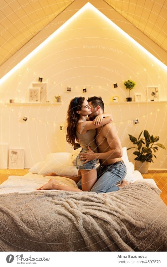 Beautiful passionate young couple hugging on the bed at home. Intimate and sensual moments of a couple making love in the bedroom. Stay at home during coronavirus covid-19 lockdown.