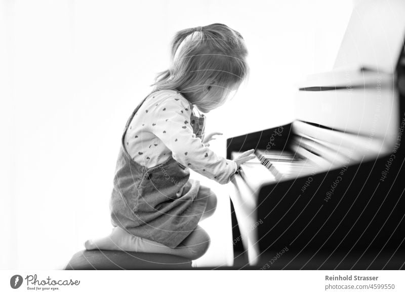 Girl at the piano Child Toddler Piano Play piano Piano keyboard Music Musical instrument Make music Playing Study Passion Fascinating inquisitive Interesting