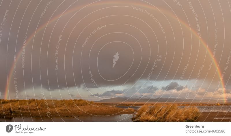 UK Weather, Sandscale, Roanhead Cumbrian Coast. Rainbow over the snowcapped Black Combe across the Duddon Estuary. uk uk weather rainbow cold black combe winter