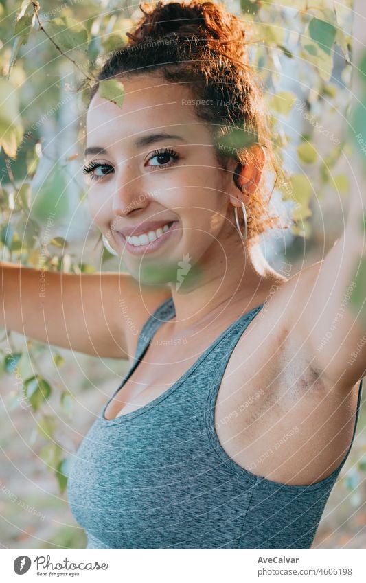 Close portrait of a smiling young african arab poc happy after finishing her training. New habits fit life new year concept. Colorful, losing weight gaining health concept