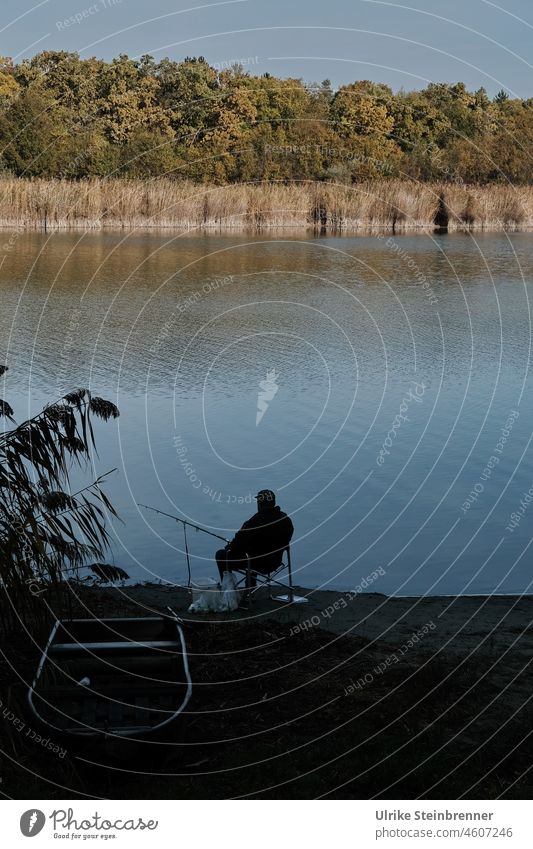 Angler next to boat on Szelid lake in Hungary Fishing boat Fisherman fishing Man free time recreational sport bank Lake reed Hiding place Berth Nature reserve
