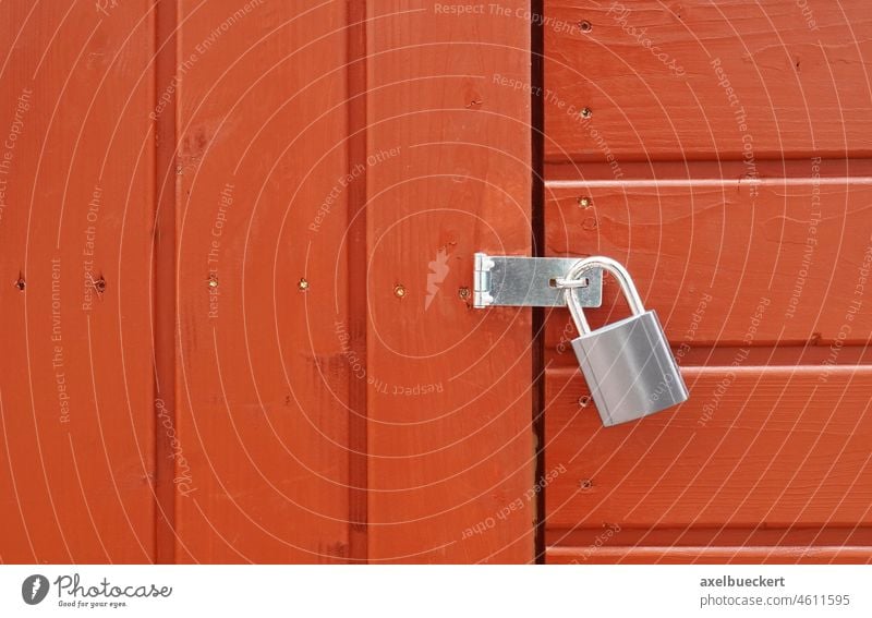 padlock on locked door of wood cabin or wooden shed background shack hut timber board abstract structure rustic copy space copyspace close-up closeup detail