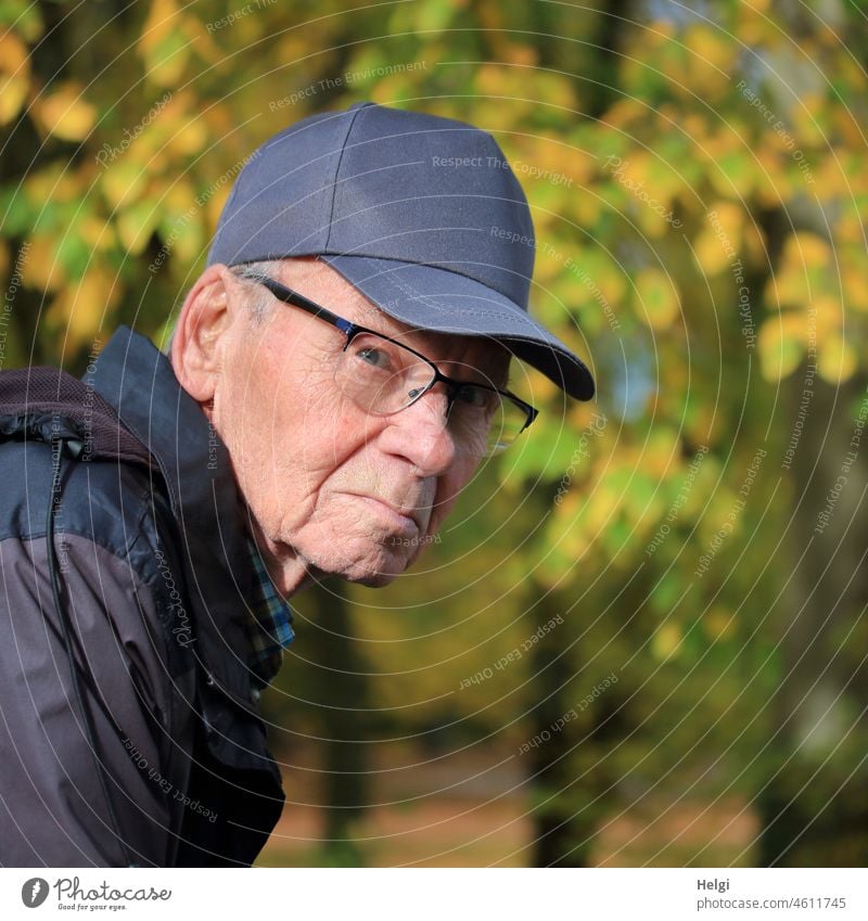 Portrait of senior citizen with cap in nature looking a little skeptically to the side Human being Man Senior citizen Looking Skeptical Eyeglasses Jacket out