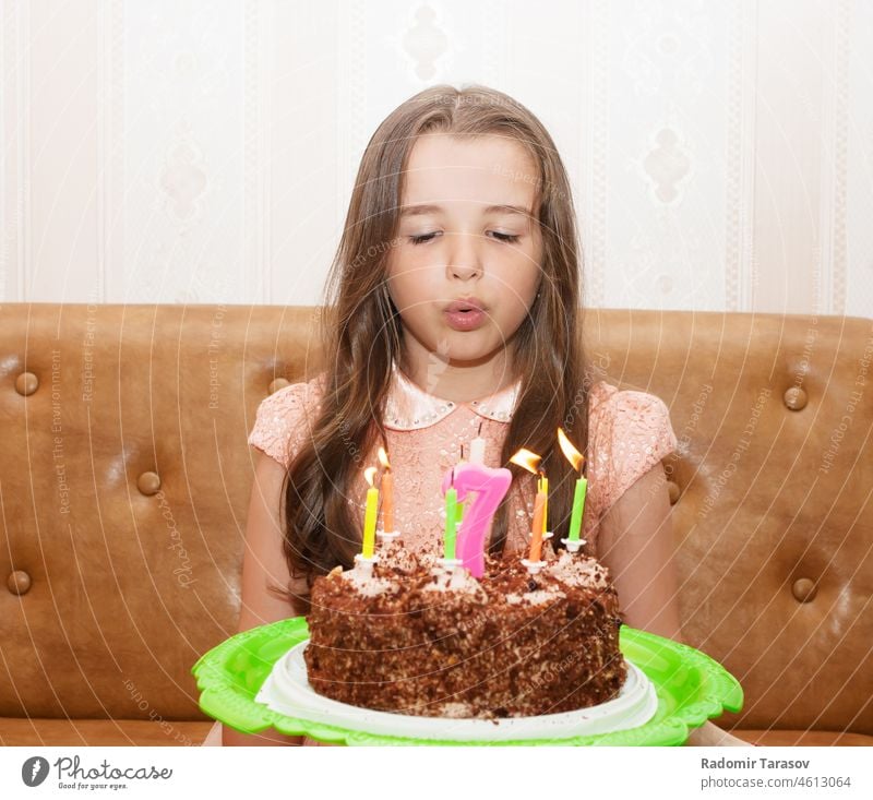 little girl blowing out the candles on a birthday cake childhood happy fun decoration cute party celebration celebrate people small home happiness person food