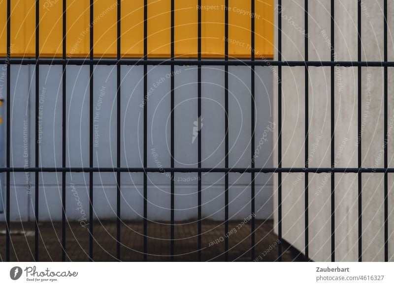 Fence in front of wall and yard, geometric in yellow and gray Grating Wall (building) Courtyard Yellow Gray Abstract rectangular Gloomy bleak locked Closed