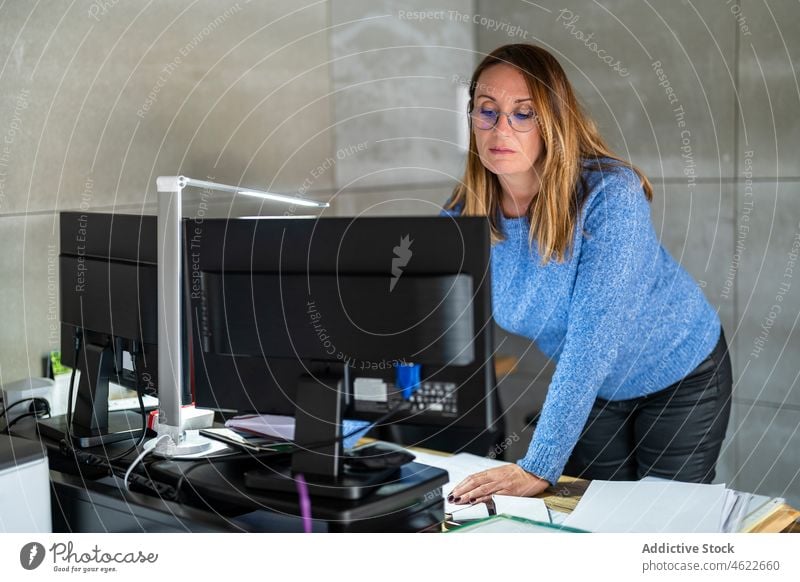 Woman working on computer in office woman browsing workplace modern business document paperwork style entrepreneur worker job lady professional workspace female