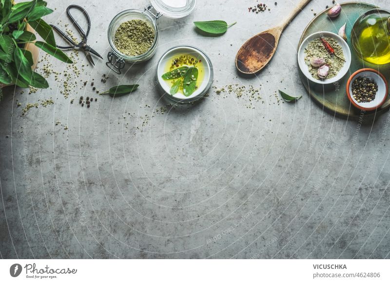 Seasoning background with flavor herbs, spices, herbal salt,  olive oil and wooden spoon for tasty cooking. seasoning top view border copy space setting above
